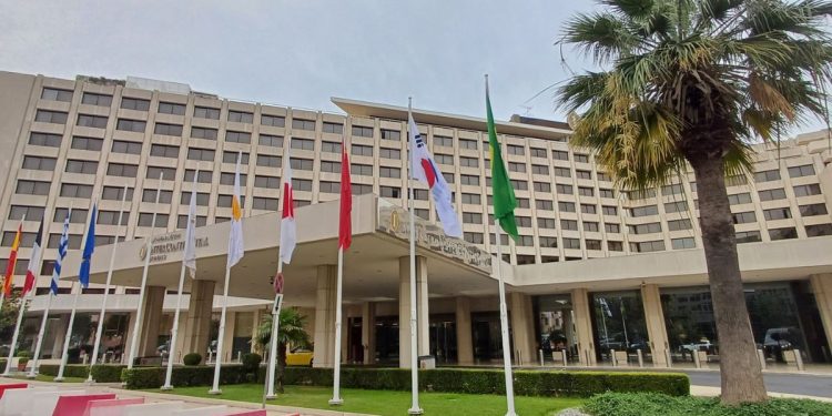 Γραφική θέα ελληνικού ξενοδοχείου την άνοιξη με τουρίστες